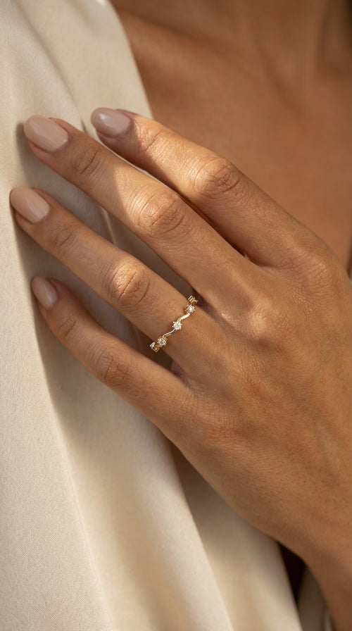 Anillo de oro amarillo 14K con diseño ondulado y circonias