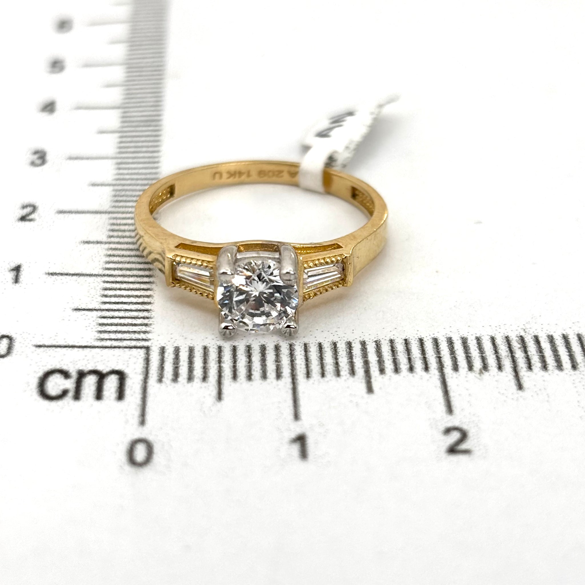Anillo de compromiso con piedra circular y circonia baguette a los lados