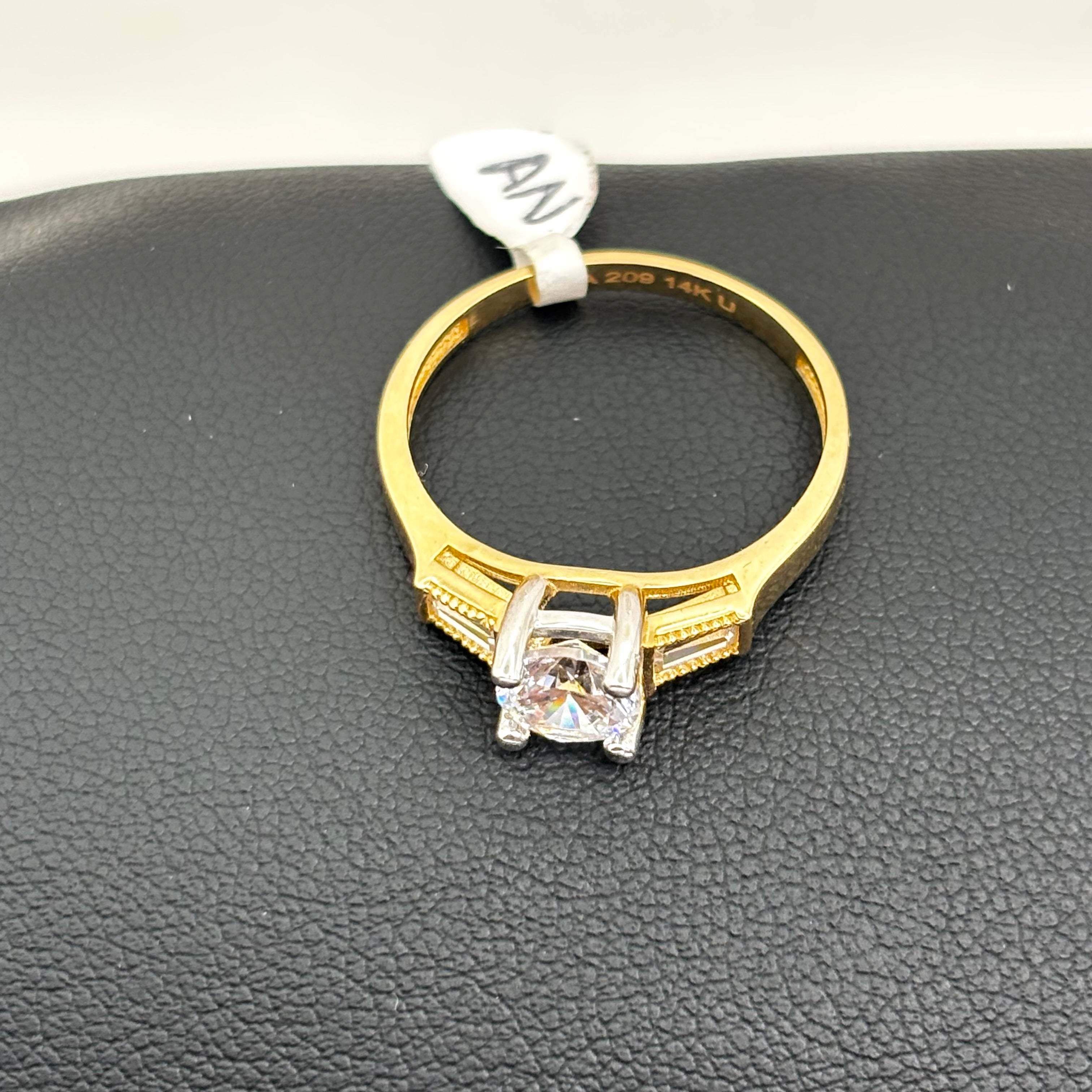 Anillo de compromiso con piedra circular y circonia baguette a los lados