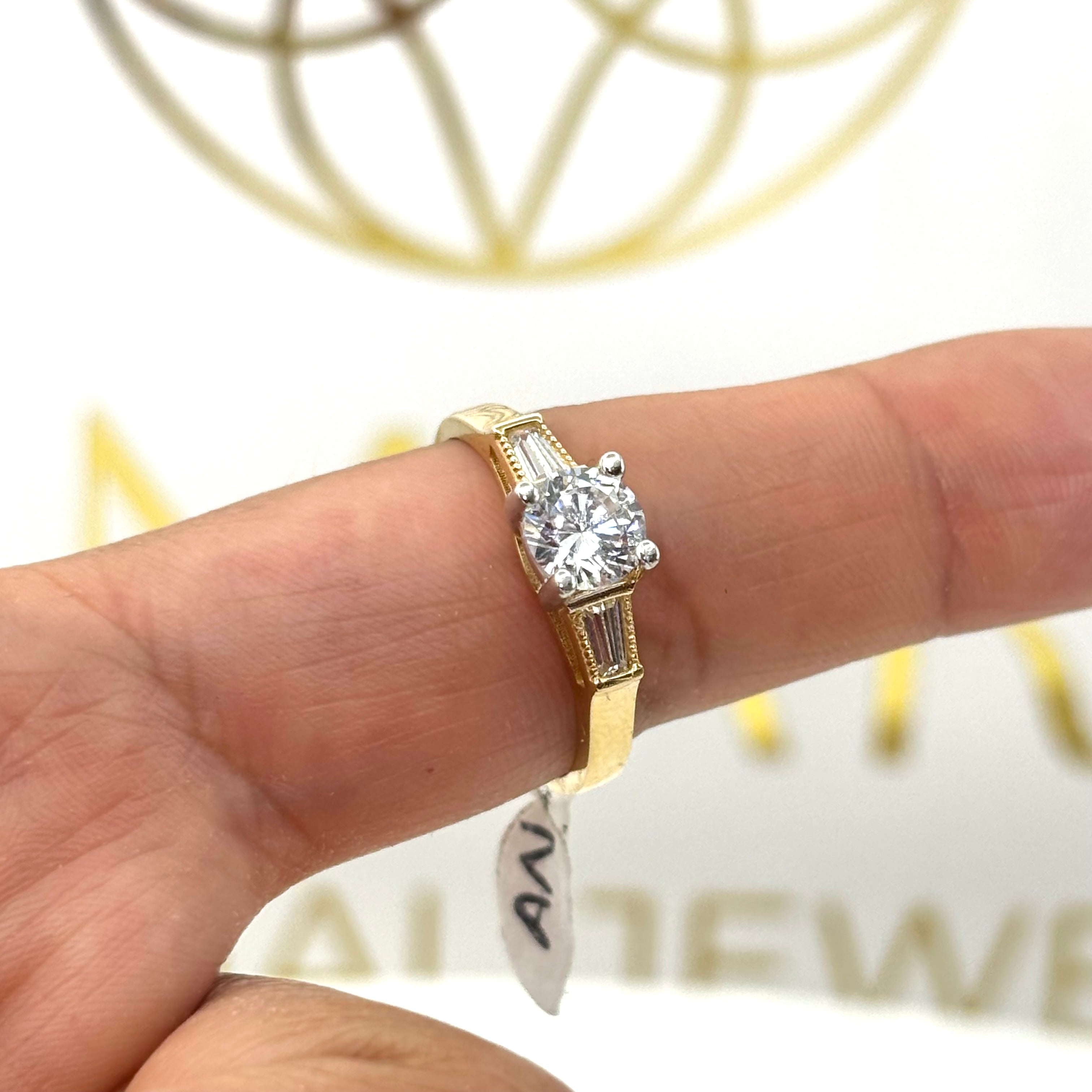 Anillo de compromiso con piedra circular y circonia baguette a los lados